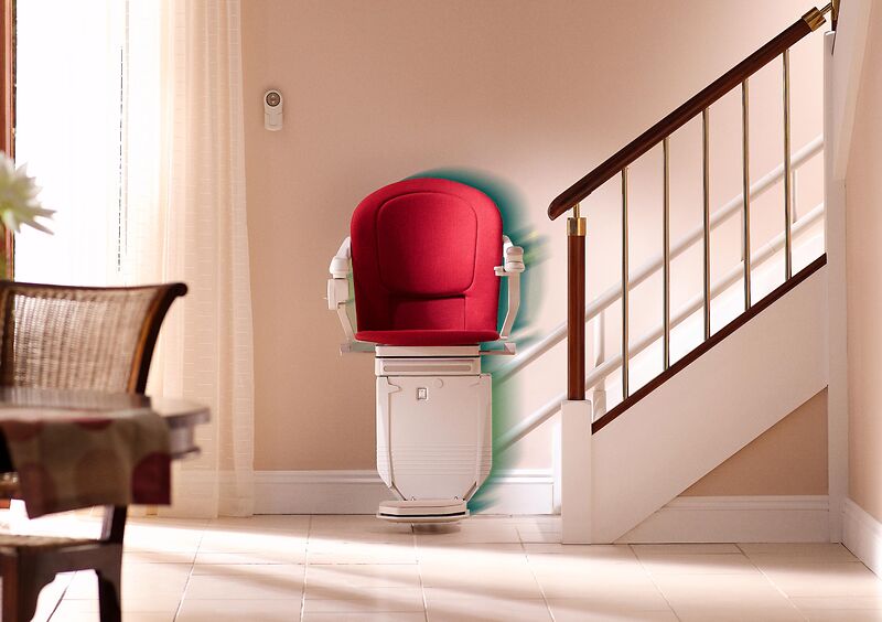 Gebrauchter Treppenlift Modell 6100 Gebrauchter Treppenlift Modell 6100 mit rotem Polster an einer Treppe im Wohnhaus