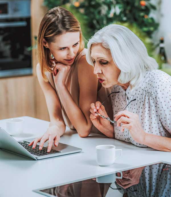 Ältere und jüngere Frau informieren sich gemeinsam am Laptop