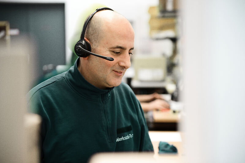 Mitarbeiter mit Headset in der Treppenlift-Werkstatt